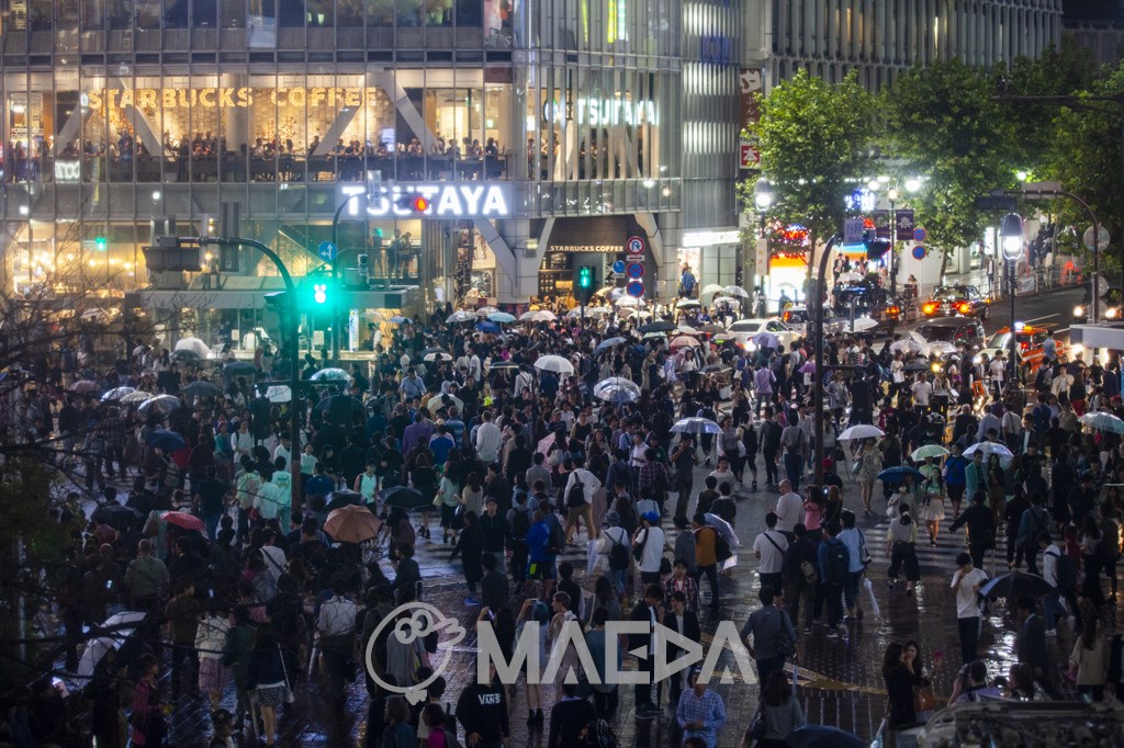 雨の中歩行者で混雑する渋谷駅前交差点