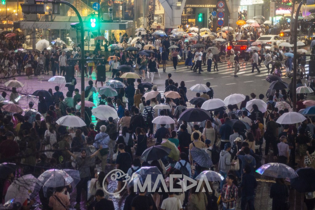 雨の中歩行者で混雑する渋谷駅前交差点